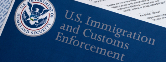 Image of documents being signed on a desk.